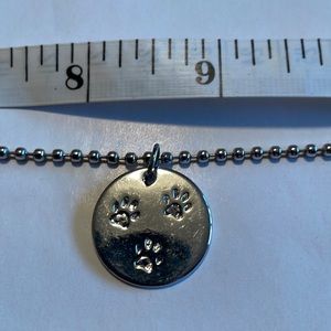 Never worn paw print necklace chain is approximately 15” print is on both sides